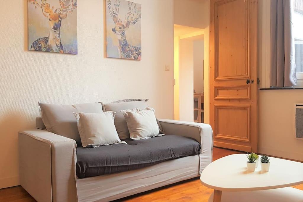 - un salon avec un canapé et une table dans l'établissement Little suite Bernadette, à Lille