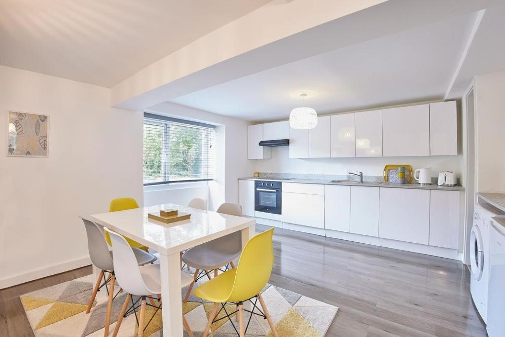 a kitchen with white cabinets and a table and chairs at Your luxurious and secluded retreat in Cornwall in Helston
