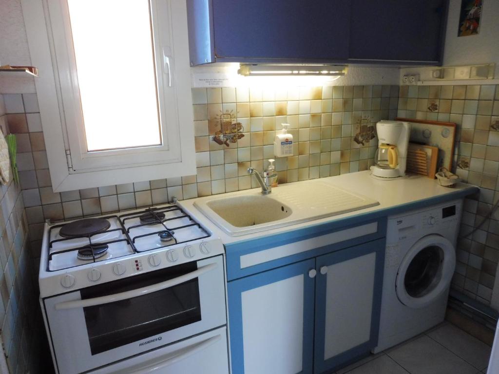 małą kuchnię z kuchenką i zlewem w obiekcie MAISONS SUR LA PLAGE Magnifique T3 mezzanine vue mer Cap d'Agde w Cap d'Agde