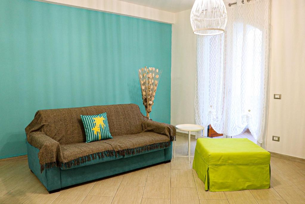 un soggiorno con divano e parete verde di Casa Mirra a Peschiera del Garda