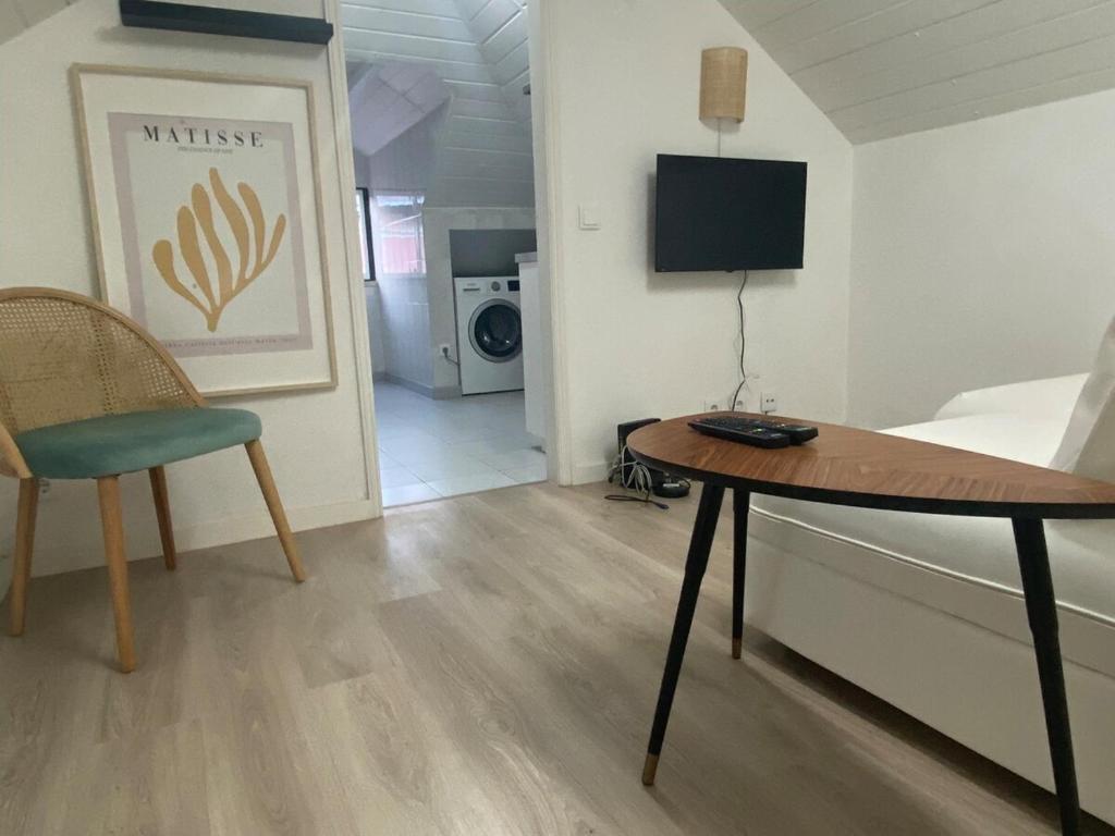 Habitación con mesa, cama y TV. en Vibrant Setúbal III, en Setúbal