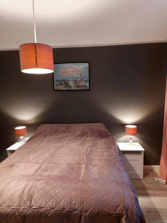 a bedroom with a bed and two end tables with lamps at Apartment near the airport in Ytri-Njarðvík