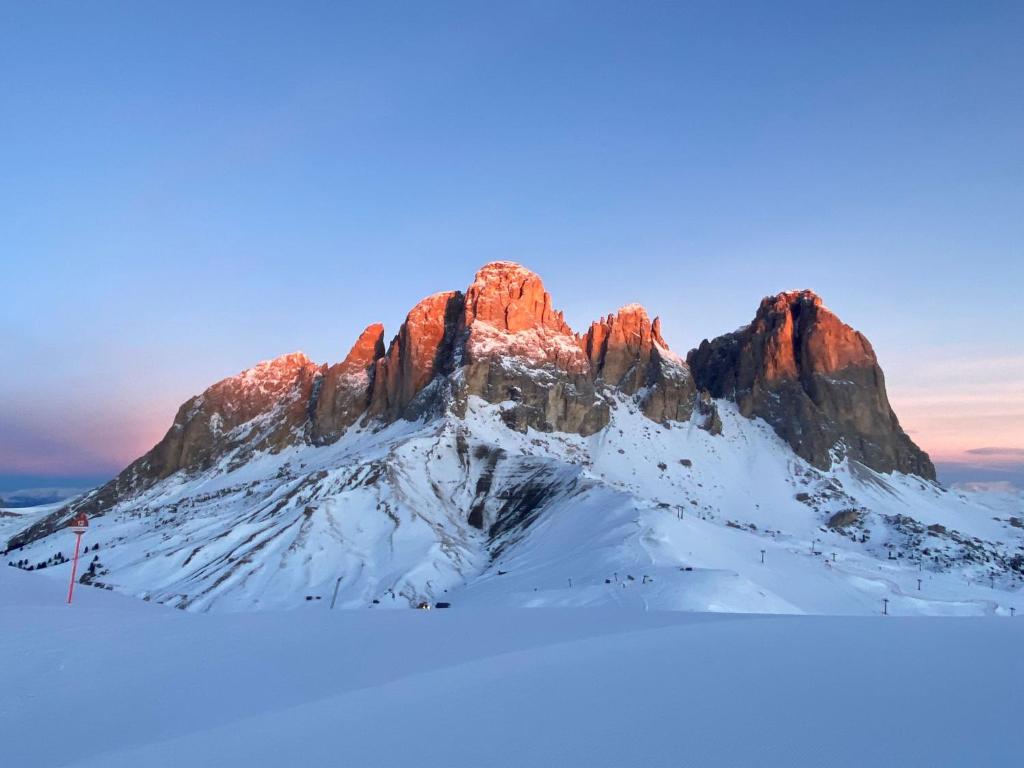 een berg bedekt met sneeuw voor een zonsondergang bij Fedaia Joy B&B in Canazei