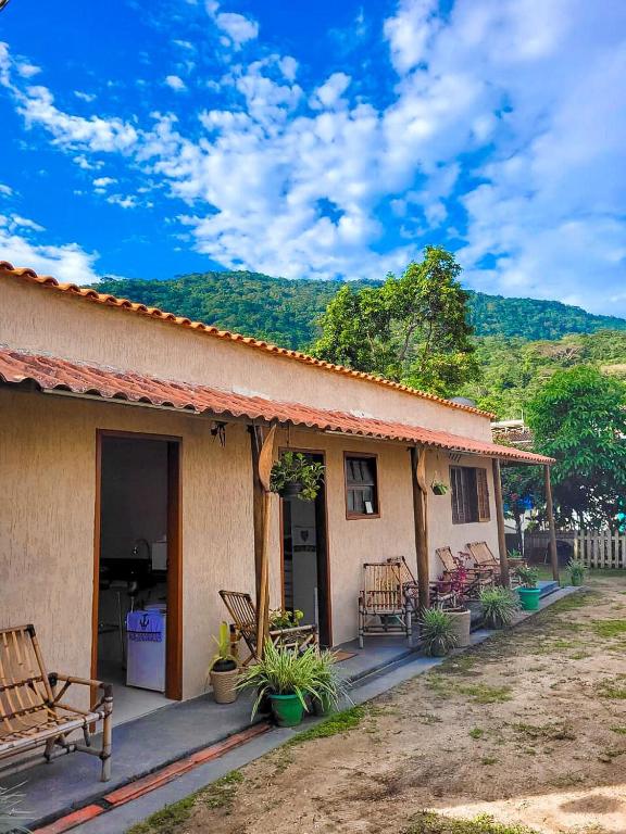 a house with benches sitting outside of it at Herdeiros do Pai in Paraty