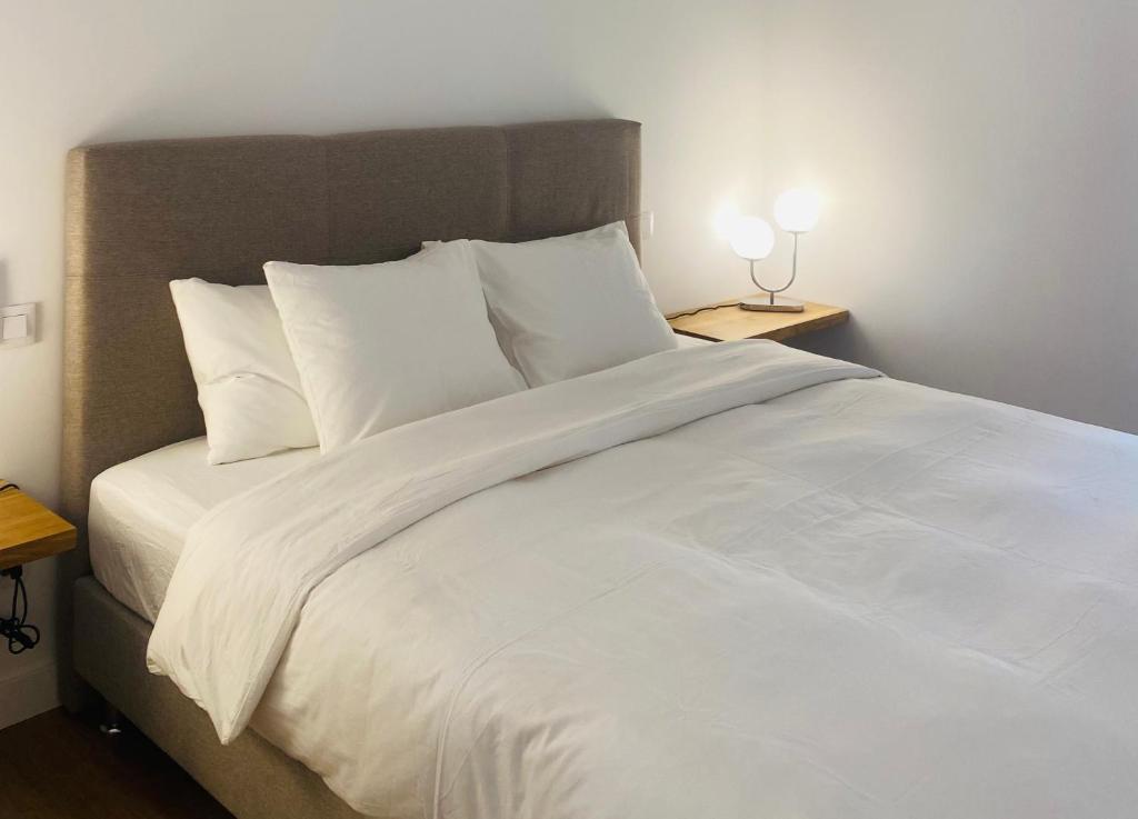 uma grande cama branca com lençóis e almofadas brancos em Hotel Apartment with 2-en suite Bedrooms em Palma de Maiorca