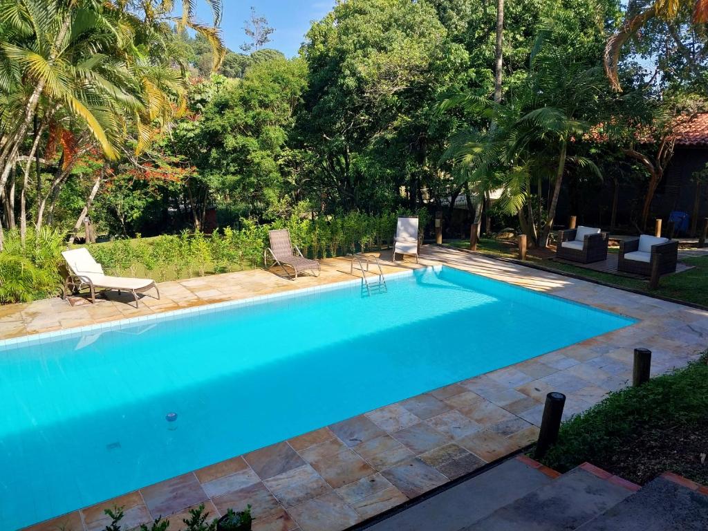 una piscina en un patio con sillas y árboles en Linda Casa de Campo Sitio Chácara em Campinas, en Campinas