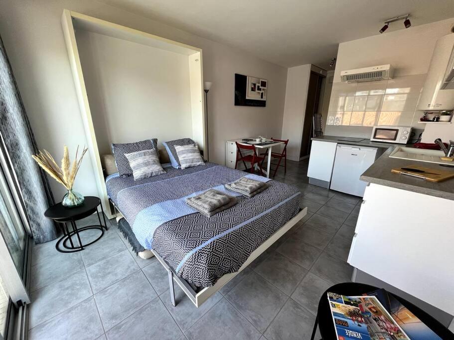 - une chambre avec un lit au milieu d'une cuisine dans l'établissement Studio équipé moderne à deux pas de la plage, à La Rudelière