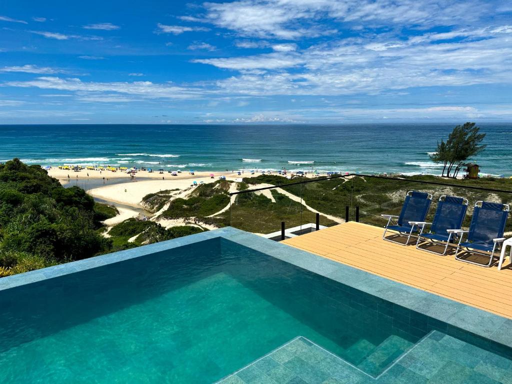 una piscina con vistas al océano en Casa Oceano Praia do Rosa, apartamentos pé na areia, Praia do Rosa, en Praia do Rosa