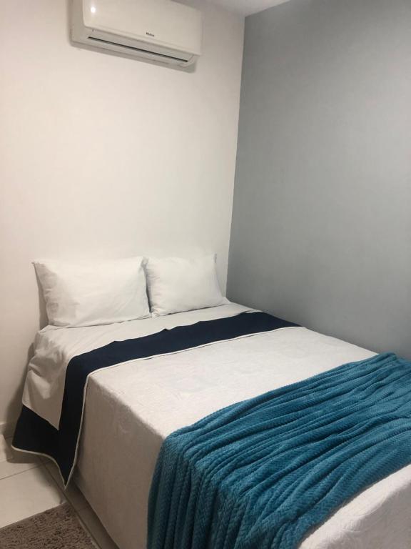 a bedroom with a bed with a blue blanket on it at Pousada LuMar Maragogi in Maragogi