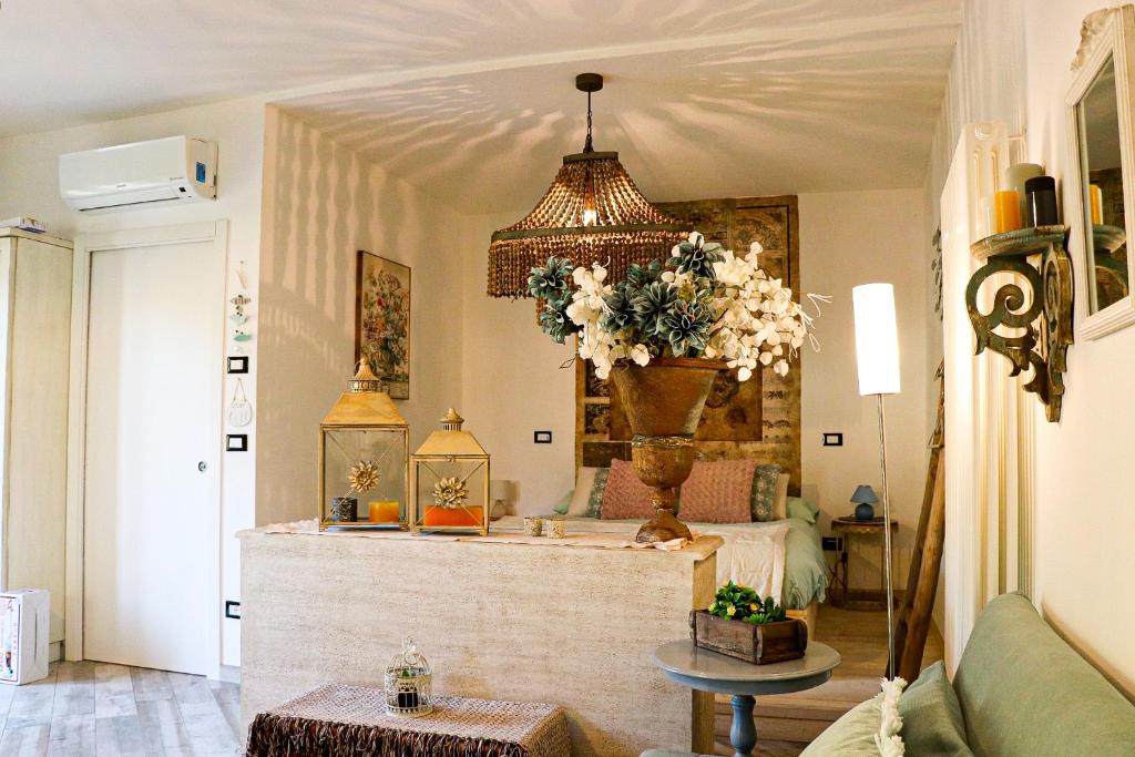 ein Wohnzimmer mit einem Kronleuchter und einem Tisch in der Unterkunft Casa Salvia in Garda