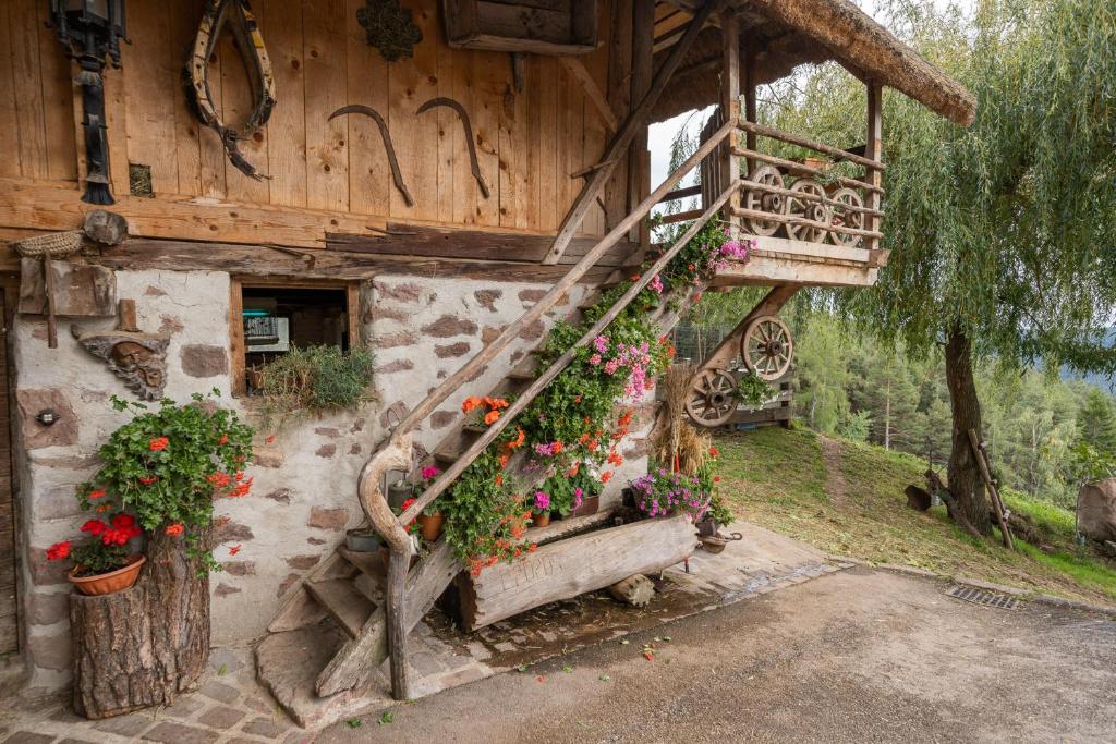a house with a staircase with flowers on it at Historisches Apartment Duregghof in San Genesio Atesino