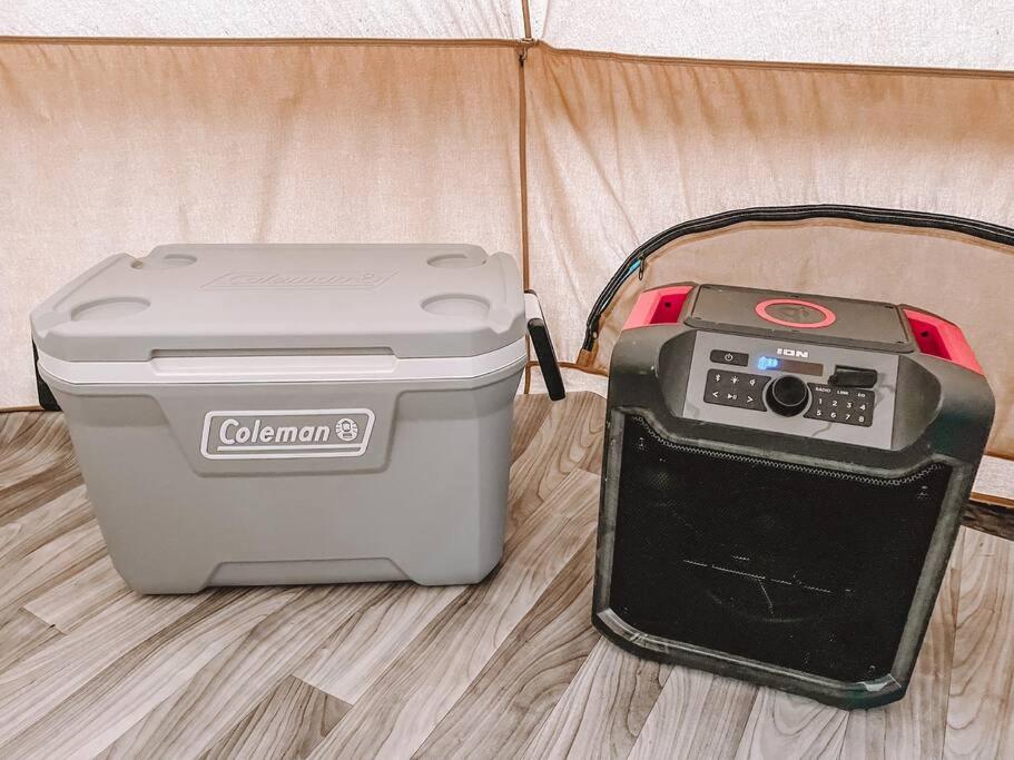 a cooler and a printer sitting on a bed at Cute Off Grid Glampsite with WiFi- 5 min from Haleiwa Town in Haleiwa