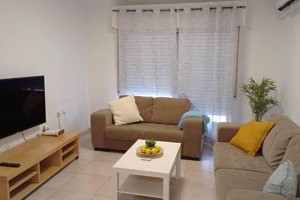 a living room with a couch and a table at One bedroom private apartment - quiet near a park in Beer Sheva
