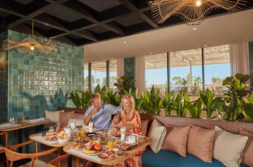 a man and woman sitting at a table in a restaurant at The Signature Level at TRS Ibiza Hotel - All Inclusive Adults Only - Entrance to Clubs included in San Antonio