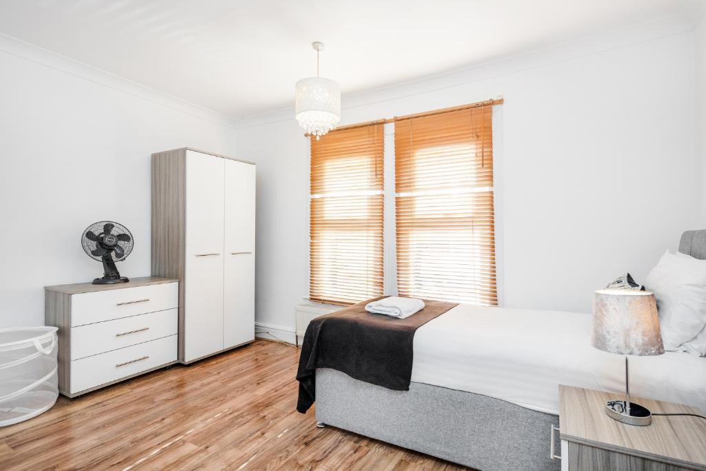 una camera bianca con un letto e una finestra di 4 bedroom House Free Parking Contractor's Haven a Chelmsford