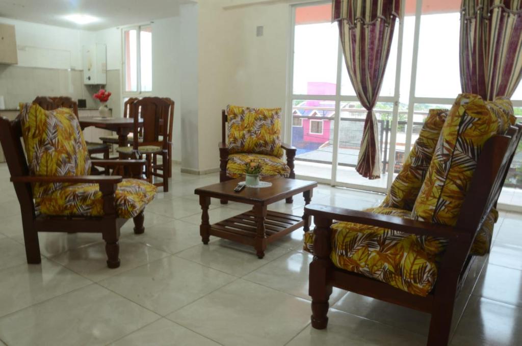 sala de estar con sillas, mesa y ventanas en Apartamentos El Mirador en El Carmen