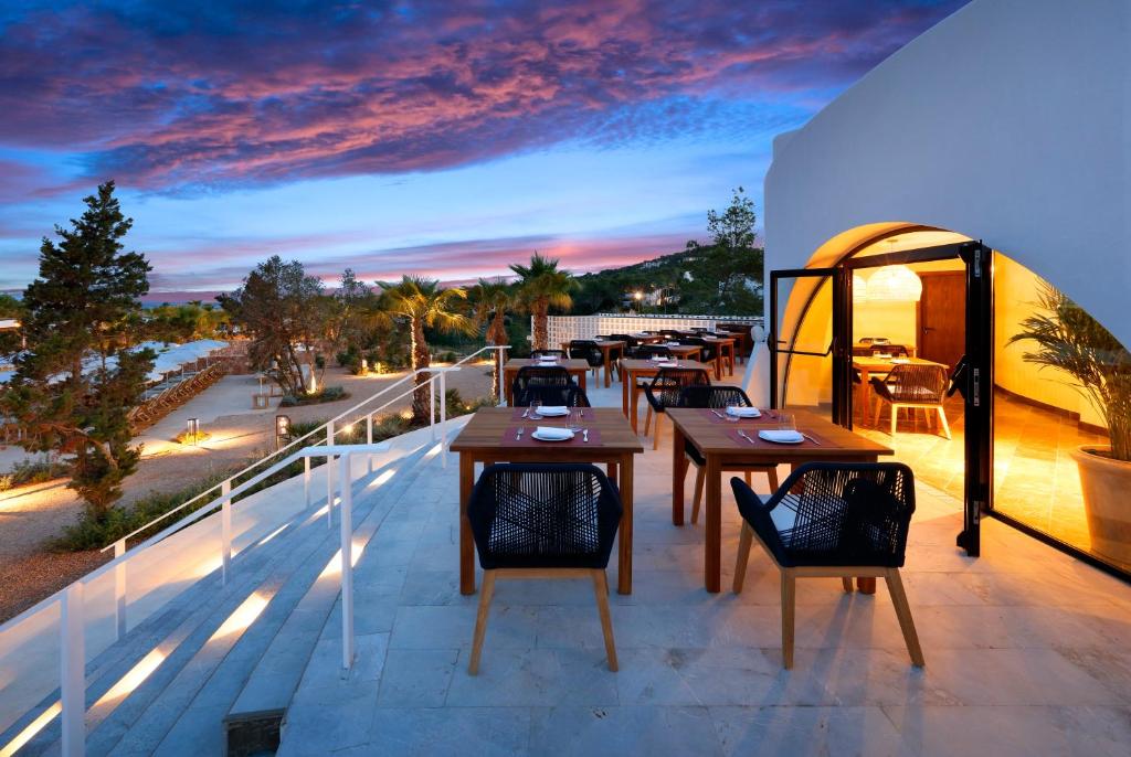 a patio with tables and chairs on a balcony at The Signature Level at TRS Ibiza Hotel - All Inclusive Adults Only - Entrance to Clubs included in San Antonio