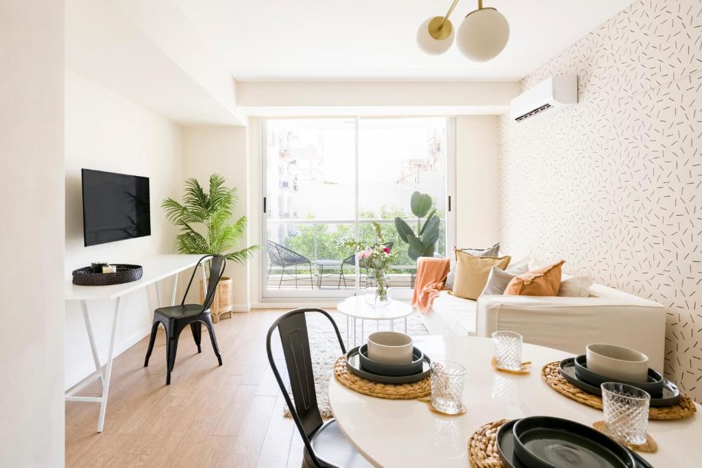 una sala de estar blanca con mesa y sillas en Top Rentals Palermo Chico en Buenos Aires