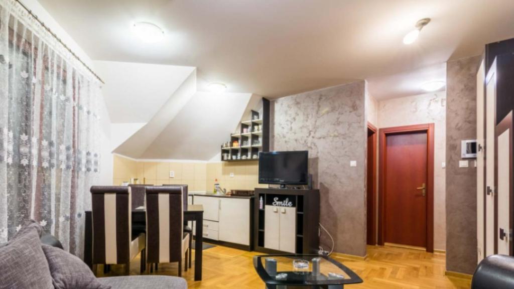 - un salon avec un canapé et une télévision dans l'établissement Apartman Adzic, à Zlatibor