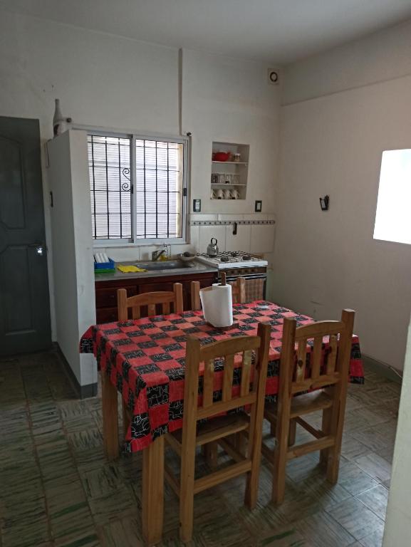 eine Küche mit einem Tisch und Stühlen sowie eine Küche mit einem Kühlschrank in der Unterkunft Casa Morales-Garcia in Campana