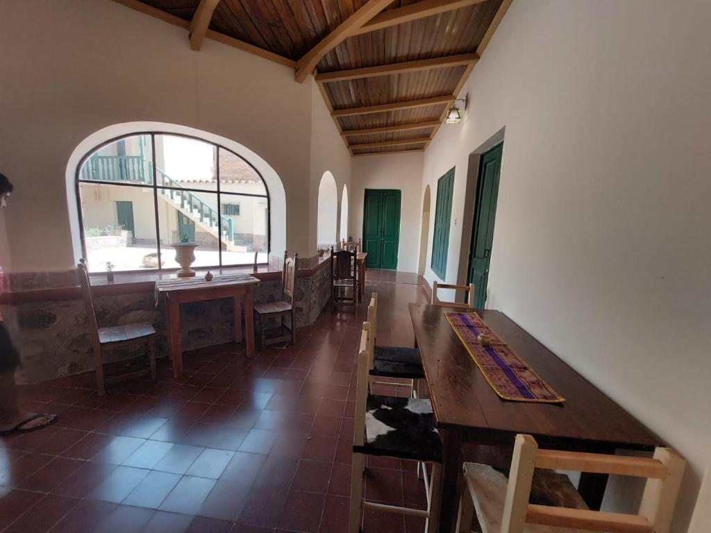 a room with tables and chairs and a window at Postales del Tiempo in Tilcara