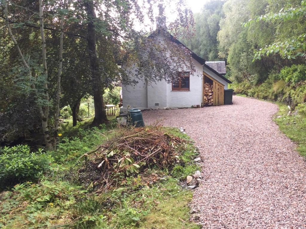 a cottage in the middle of a gravel road at Druimbhan, 1 Railway Cottage, in Lochailort