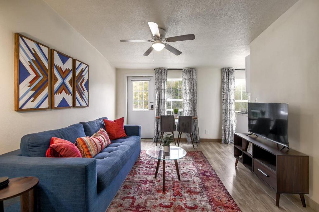 uma sala de estar com um sofá azul e uma televisão em Magnolia on Lake Travis area em Austin