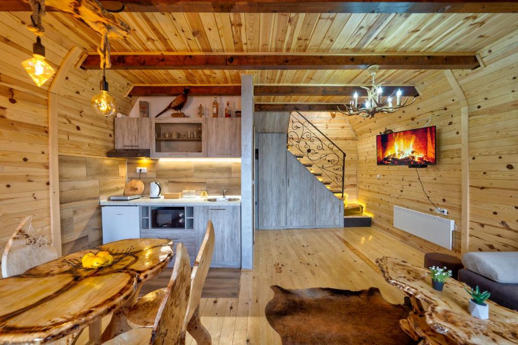 una cucina e un soggiorno con tavolo in una cabina di Vila Deniri a Zlatibor