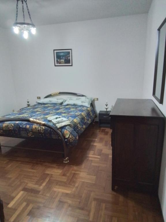 sypialnia z łóżkiem i drewnianą podłogą w obiekcie Casamarche w mieście Montalto Dora