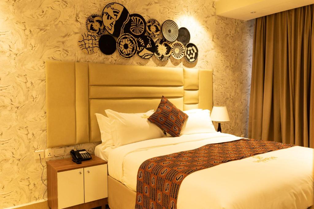 1 dormitorio con 1 cama grande y edredón blanco en Urban Park Suites, en Kigali