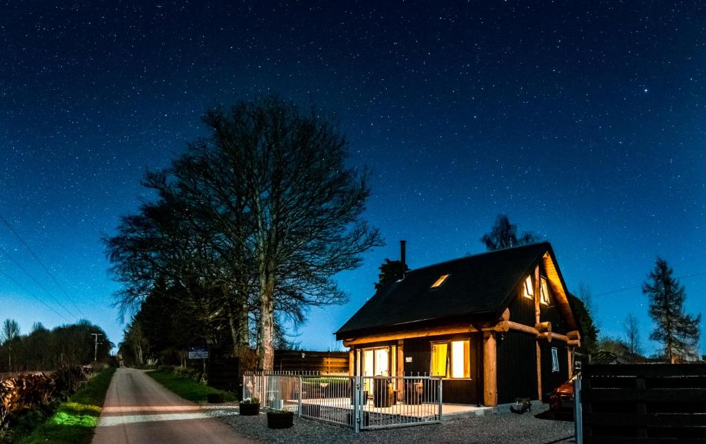 uma casa à noite com um céu estrelado em Rowanlea Lodge With Hot Tub em Marykirk