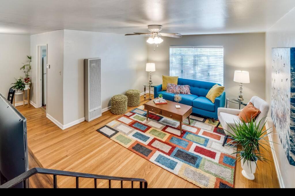 uma sala de estar com um sofá azul e um tapete em Blissful Stay in Alamo Heights em San Antonio