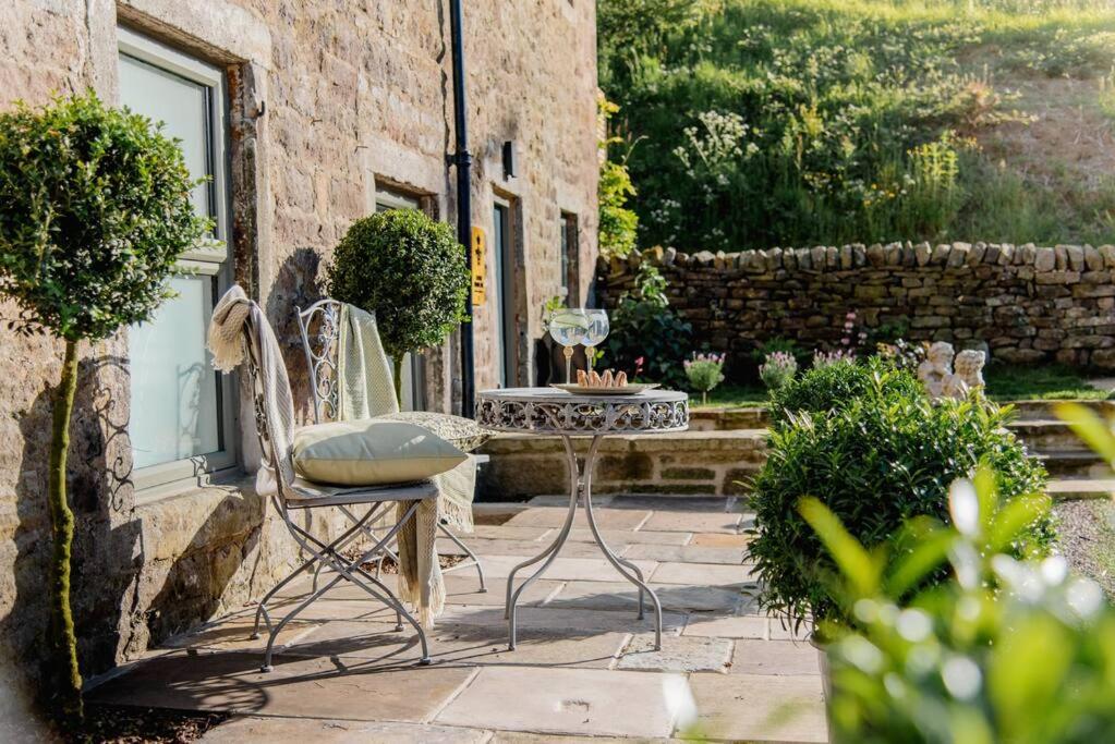 a patio with a table and chairs in a yard at Luxury 4 Bed Dales Retreat Private Walled Garden All Ensuite Sleeps 8 SuperKing 1 Double 2 King 1 in Embsay