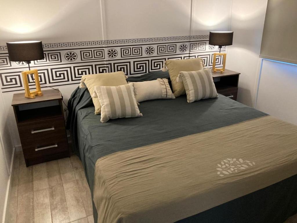 a bedroom with a large bed with two lamps on it at Monte Aromas in Roldán