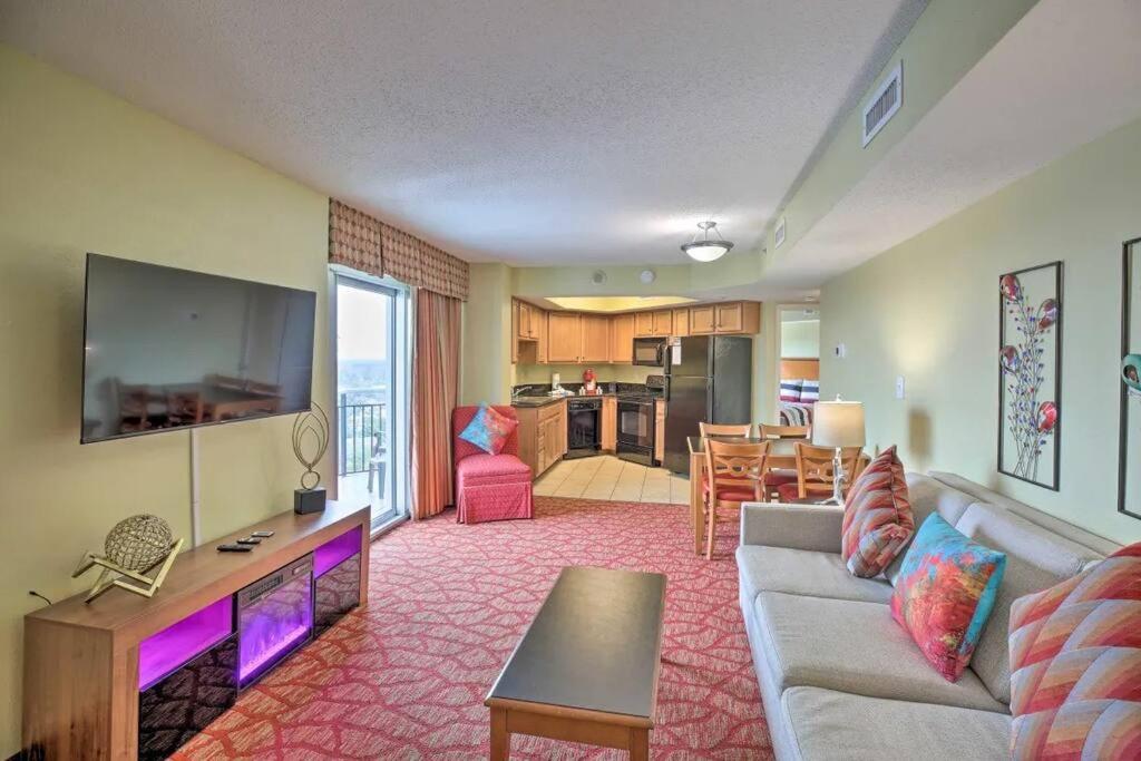 uma sala de estar com um sofá e uma televisão de ecrã plano em Bayview Resort Penthouse w/ Sunset Views em Myrtle Beach