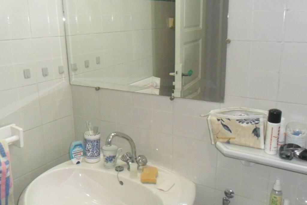 Baño blanco con lavabo y espejo en Villa meublée à skanes Monastir, en Monastir