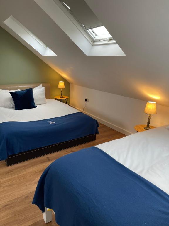 a bedroom with two beds with blue and white sheets at Cambridge Studios and Suites by Tas Accommodations in Cambridge