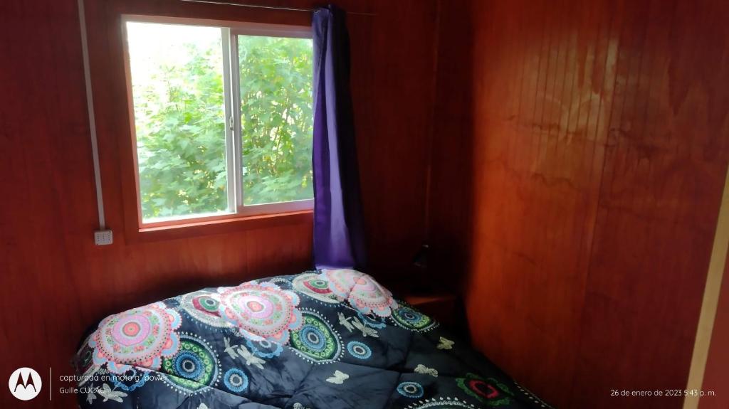 1 dormitorio con cama y ventana en Cucao Chiloe, en Chonchi