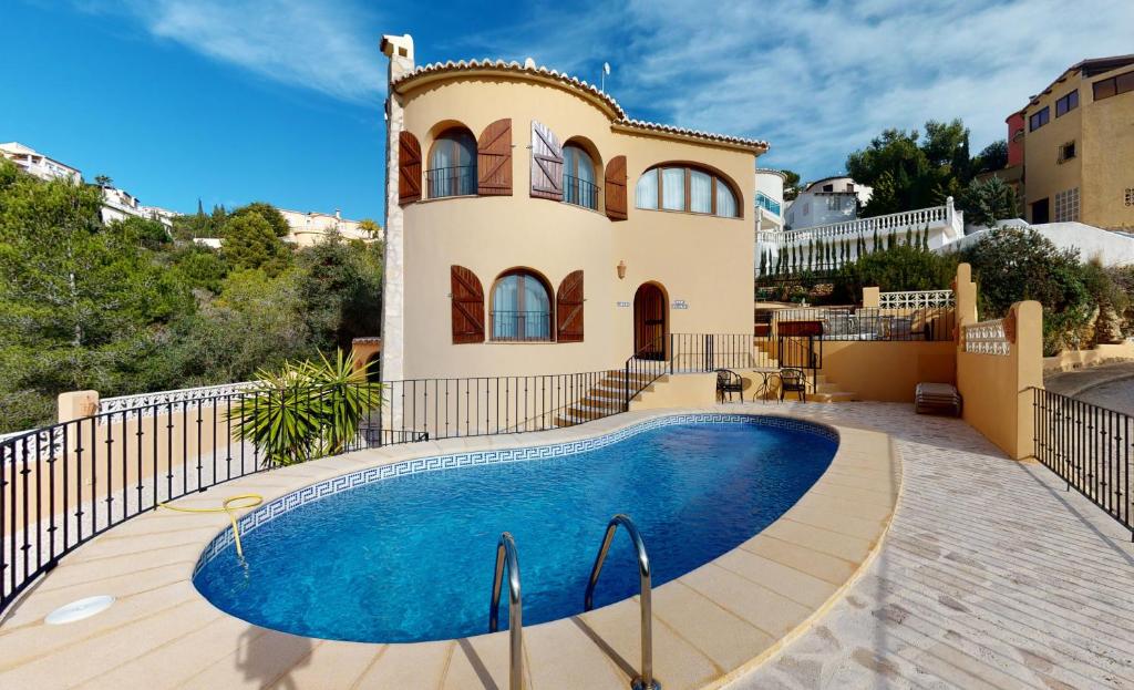 Villa con piscina frente a una casa en Villa Encinas, en Cumbre del Sol