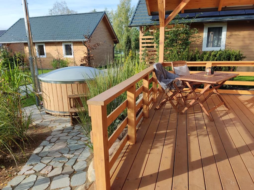 a wooden deck with a table and a wooden fence at Domek z balią in Chmielno