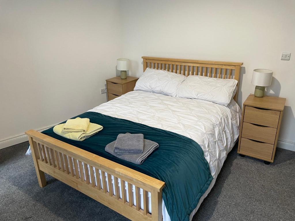 1 dormitorio con 1 cama de madera y 2 mesitas de noche en Casement Townhouse, en Belfast