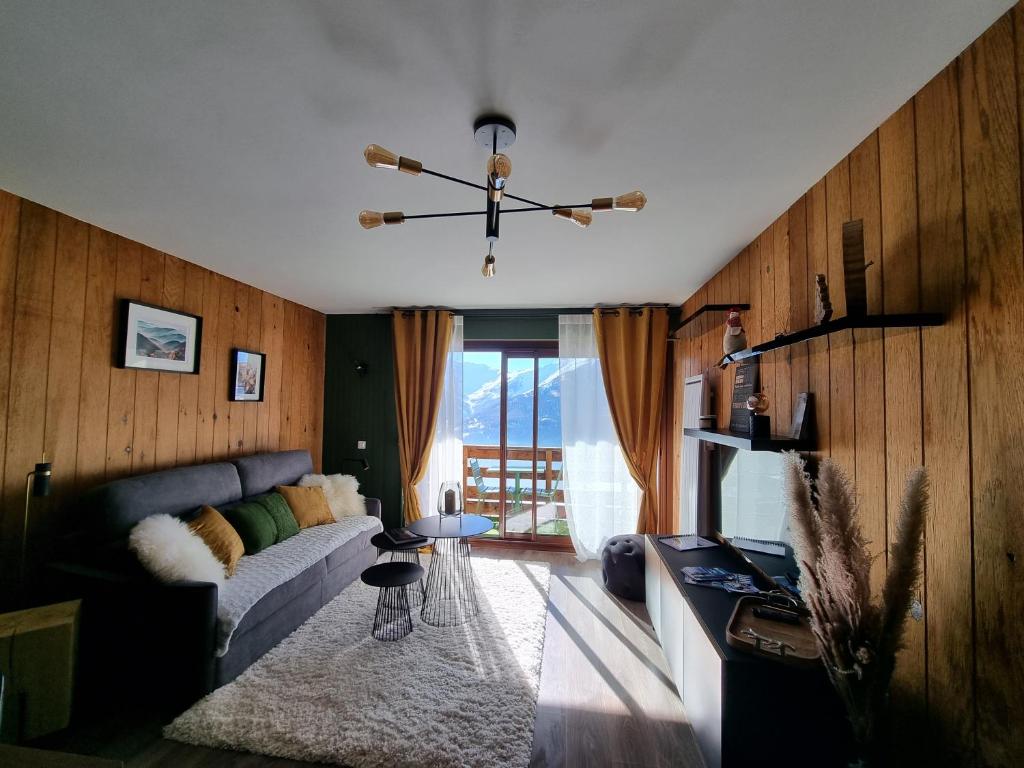 a living room with a couch and a chandelier at STUDIO - ROCHES ROUSSES b in Orcières