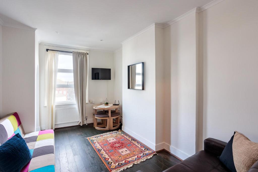 uma sala de estar com um sofá e uma janela em Entire luxurious flat sleeps 4 persons em Londres