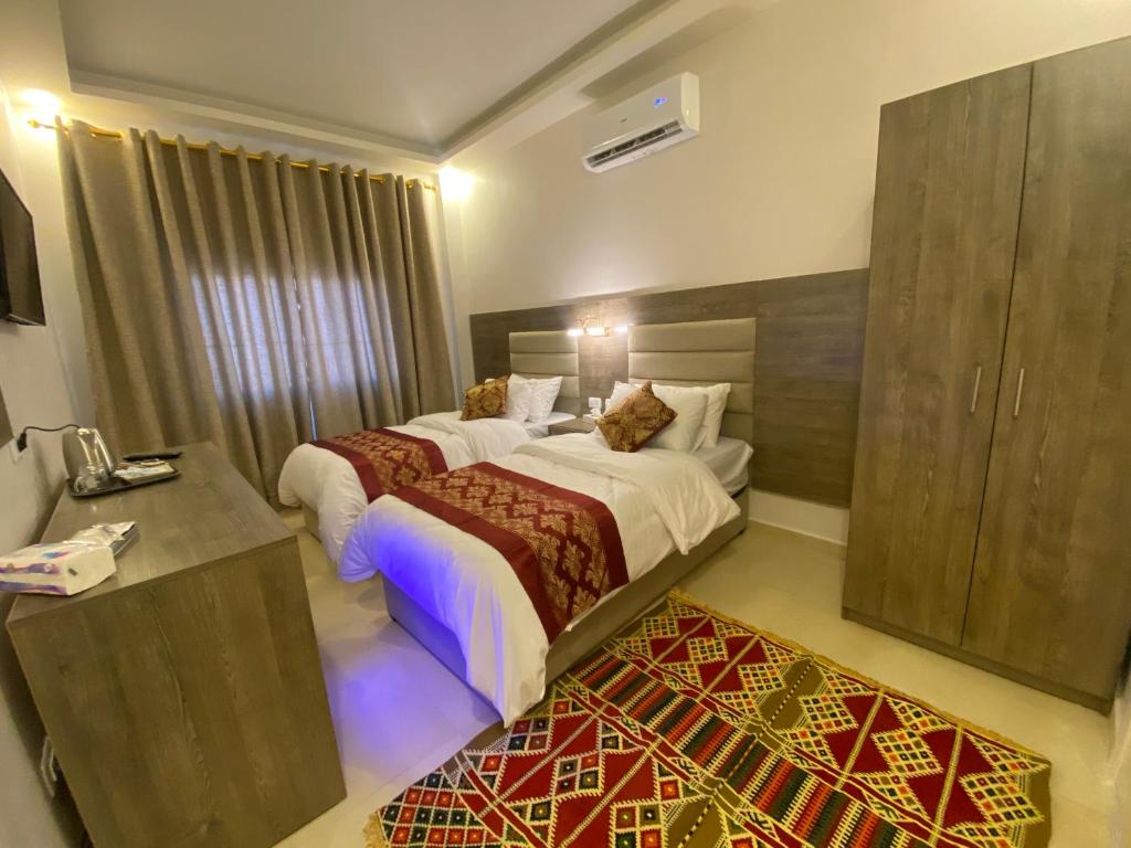 ein Hotelzimmer mit einem Bett und einem Schreibtisch in der Unterkunft Petra Oleander Hotel in Wadi Musa