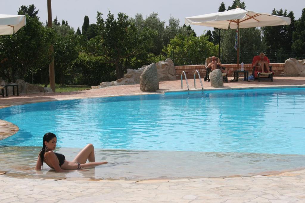 una donna seduta in acqua in piscina di Residenza La Vigna a Parghelia