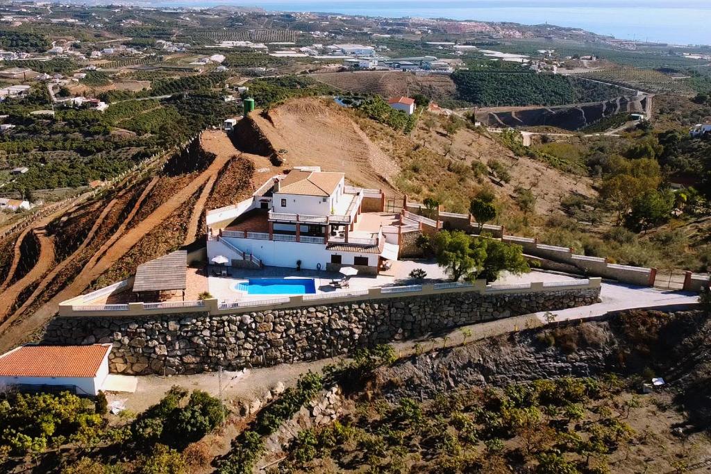 an aerial view of a house on a hill at Villa El Palomar Azul with pool and sea view in Benajarafe