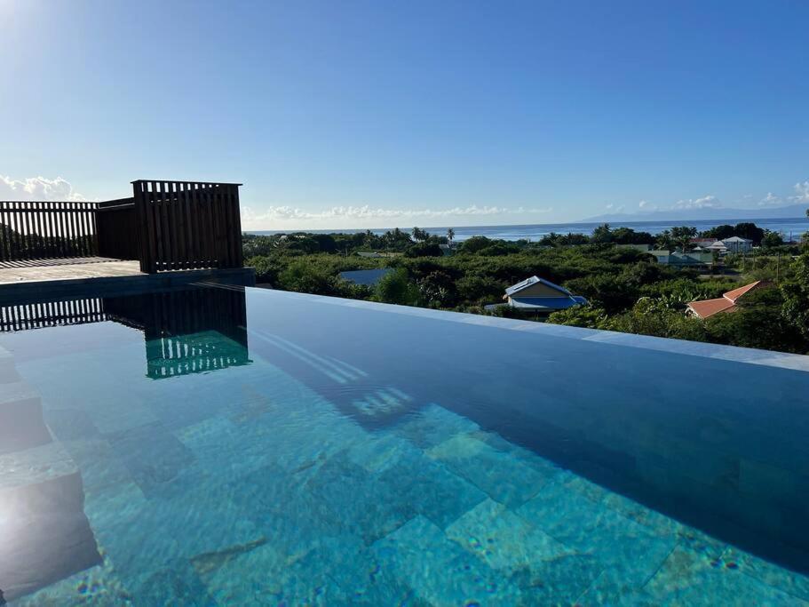 a swimming pool with a view of the ocean at Villa Acoma Lodge in Grand-Bourg