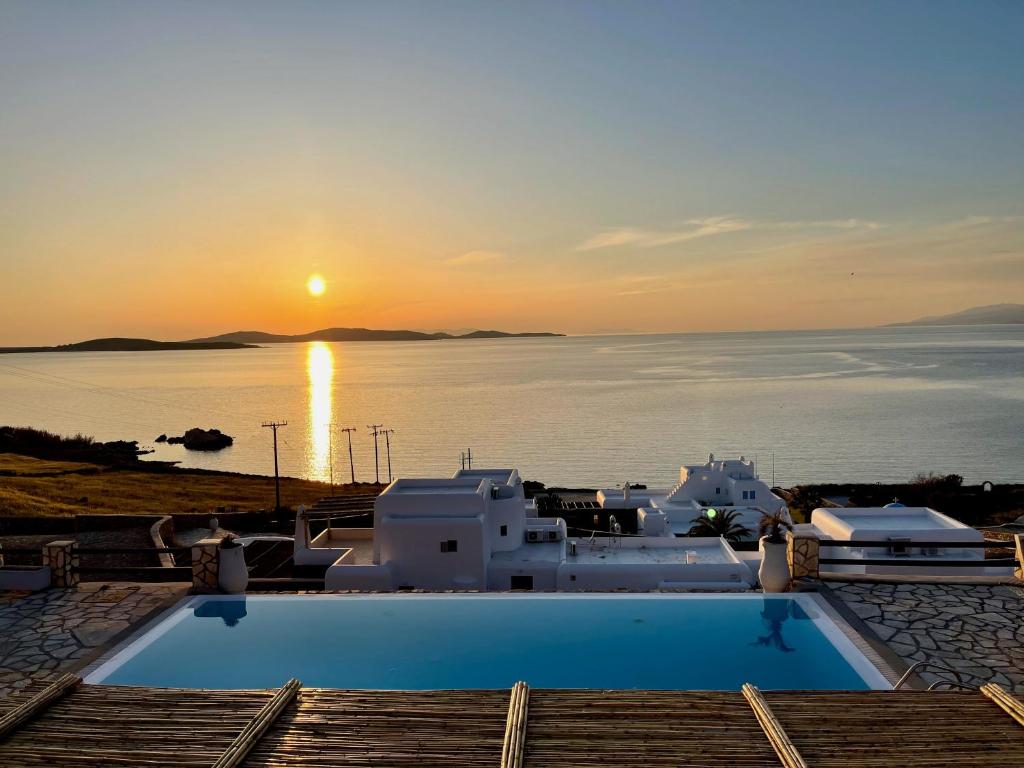 a pool with a view of the ocean at sunset at Salty View in Mikonos