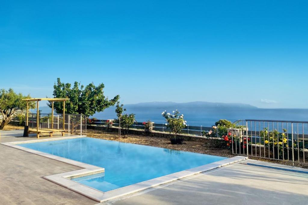 ein Schwimmbad mit dem Ozean im Hintergrund in der Unterkunft Villa Roz by Villa Plus in Plateies