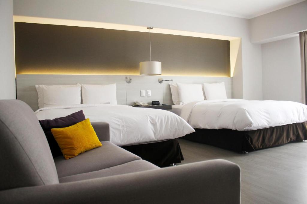 Un pat sau paturi într-o cameră la Sol de Oro Hotel & Suites